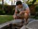 How to Tell If Your Blocked Drain Is a Quick Fix or a $10,000 Problem Homeowner checking an underground utility pit for a possible hidden water leak