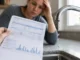 Why Is My Water Bill So High? 10 Hidden Causes Australian Homeowners Often Miss Australian homeowner checking a high water bill next to a dripping kitchen tap