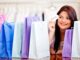Special Offers You Can Not Resist Smiling woman holding a 'SALE' card, surrounded by colorful shopping bags, representing a successful shopping spree and discounts bundles
